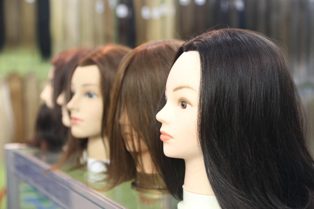 Vergelijking echt haar tegenover synthetische pruik met natuurlijke uitstraling en verschillende stylingmogelijkheden